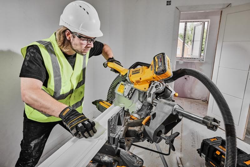 DEWALT saw DCS781X2-QW, DCS781X2 in use on construction site by worker in safety gear.